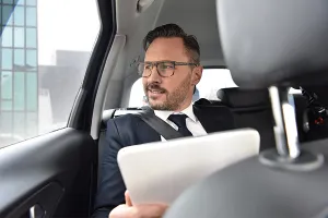 An image of a business man in the back of a taxi