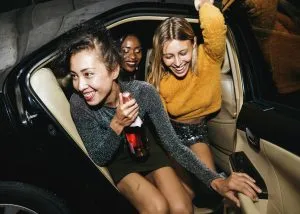 An image of of some women on a night out getting out of a taxi